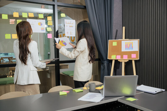 Business women meet, busy team people work on project, meeting to analyze important data, presentation charts, and graphs, collaborating for success in modern office conference room environment - Powered by Adobe