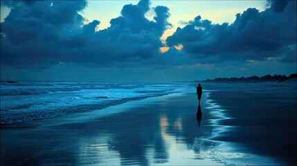 A silhouetted person walks along a wet beach at dusk. The sky is filled with dark, dramatic clouds reflecting in the water.