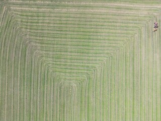 Aerial view of a tractor preparing hay in the field for making straw bales - Vue a&eacute;rienne d'un tracteur pr&eacute;parant le foin dans le champ pour la confection des bottes de paille
