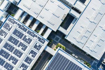 Aerial view of modern factory roofs with solar panel arrays