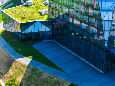 Aerial view of modern glass office building with green lawn