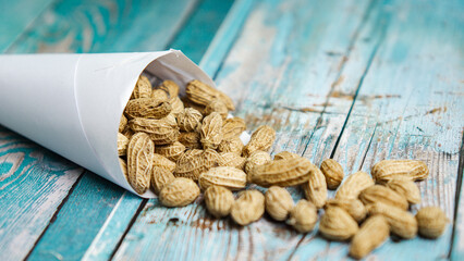 Boiled peanuts wrapped in cone-shaped paper on a rustic table