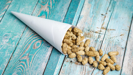 Boiled peanuts wrapped in cone-shaped paper on a rustic table