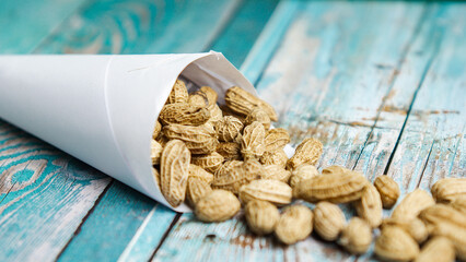 Boiled peanuts wrapped in cone-shaped paper on a rustic table