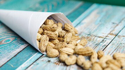 Boiled peanuts wrapped in cone-shaped paper on a rustic table