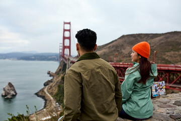 A man and a woman sit in the bridge's lookout point