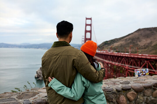 Embracing couple enjoys a view of the Golden Gate Bridge
