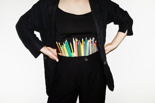 Person wearing blazer and having art colourful pencils inside blazer