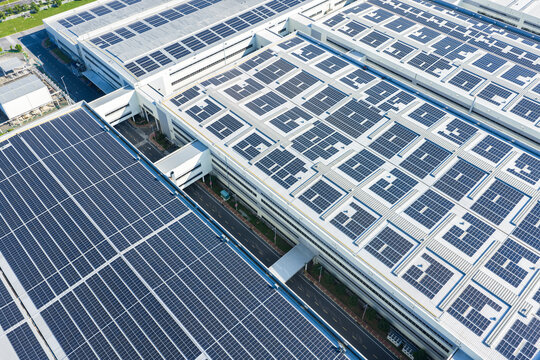Aerial view of modern factory roofs with solar panel arrays
