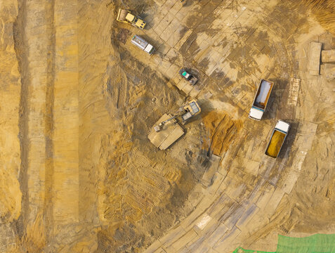 Aerial Construction Site with Dump Trucks and Excavator