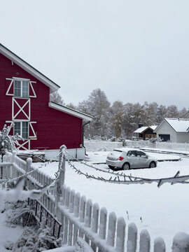 Red house exterior and car in snow