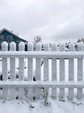 White picket fence covered in fresh snow