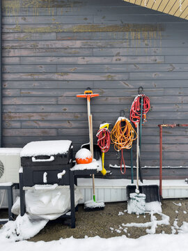 Backyard tools and grill covered by winter snow