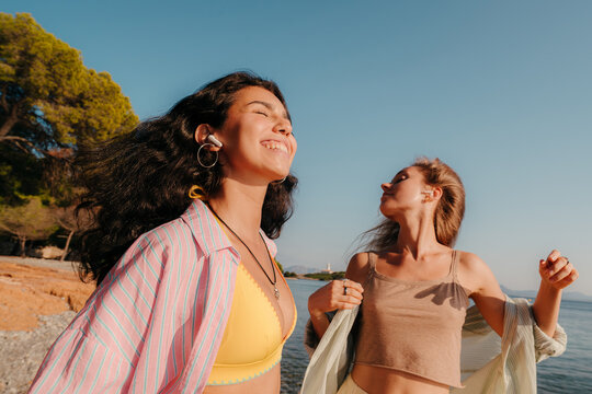 Best friends dancing to music wearing earphones