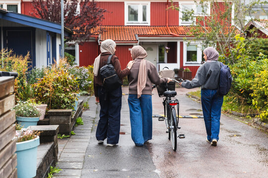 Three Friends Walking and Talking with a Bicycle