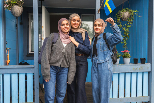 Three Friends Posing with a New House Key - Powered by Adobe
