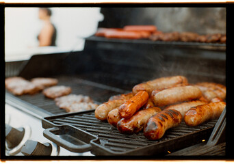 Grilling Sausages and Meats at Outdoor Barbecue on Sunny Day