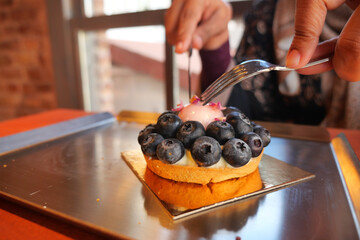 Enjoying a blueberry dessert at a cozy cafe in the afternoon