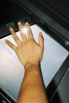 A hand towards the sky from inside a room
