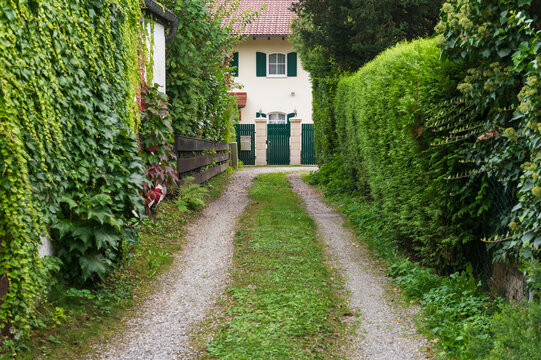 Gravel Path Leading to Cottage with Green Gate Entrance