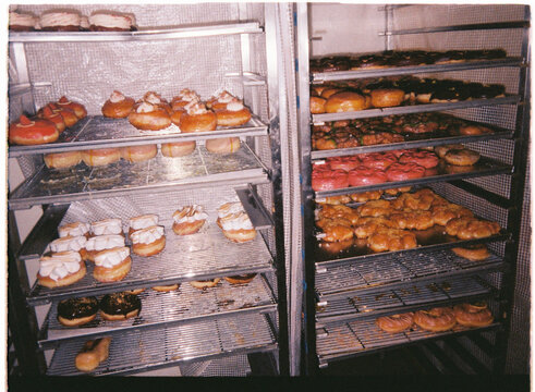 Freshly baked donuts cooling on bakery racks