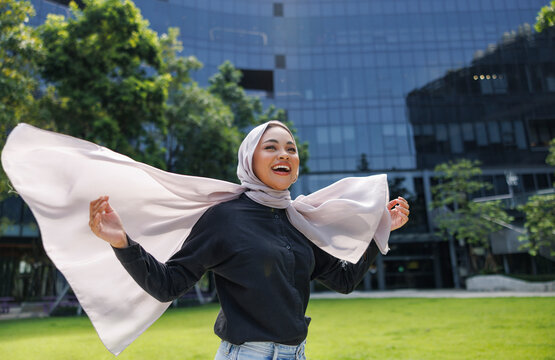 Smiling woman in hijab enjoys the outdoors.