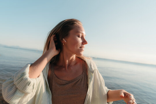 Young woman dancing to music with wireless earphones