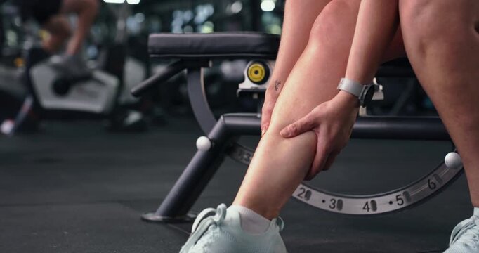 Person, hands and fitness with leg injury for muscle tension, sprain or overworked in gym. Closeup, active or calves with sore shin or bone for strain, joint inflammation or accident in health club