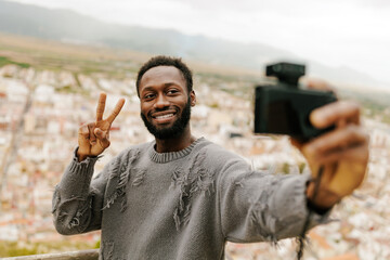 Young man taking a selfie while making the peace sign.