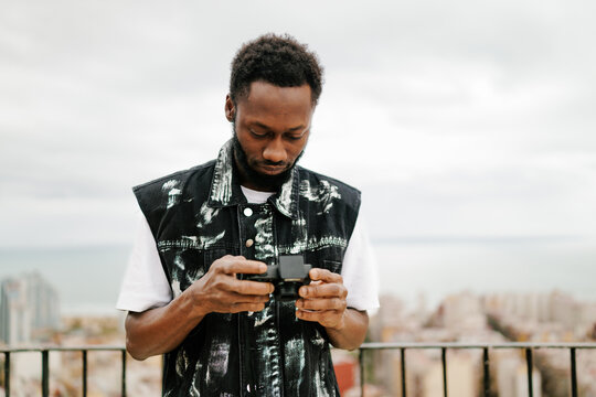 Man adjusting camera settings on rooftop