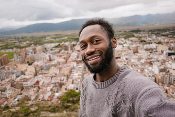 Happy man taking a selfie with views of the city.