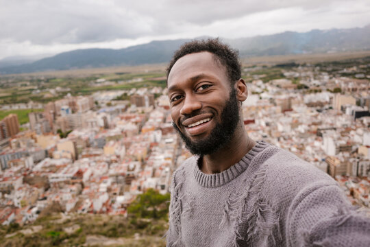 Happy man taking a selfie with views of the city.