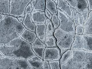 sidewalk with cracks and anti-icing chemicals. urban winter background. closeup.
