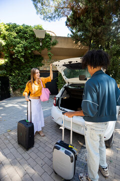 Traveling Couple closing car trunk when arriving to destination