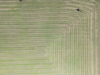 Aerial view of a tractor preparing hay in the field for making straw bales - Vue a&eacute;rienne d'un tracteur pr&eacute;parant le foin dans le champ pour la confection des bottes de paille
