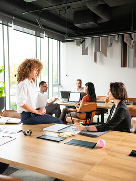 People Chating In The Bright Busy Office among Desks
