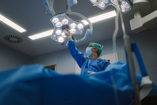 Surgeon adjusting operating room lamp before surgery