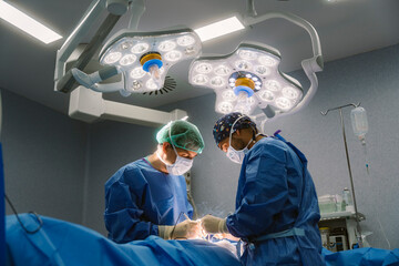 Surgeons performing complex operation in hospital operating room