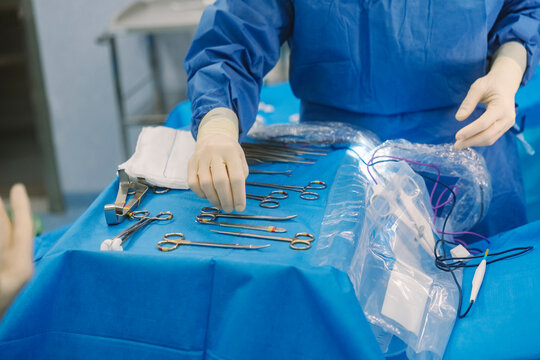 Surgeon preparing surgical instruments for medical procedure