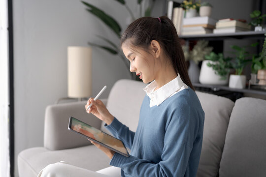 Asian woman Graphic designer working on digital tablet. artist drawing on graphic tablet female Artist Creative Designer sketch graphic drawing creative studying work on tablet at home