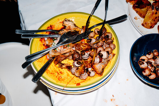 plates with chicken bones and snail shells after dinner