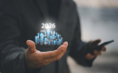 Businessman drawing digital growth arrows and bar graph with 2026 target. Futuristic concept for business goals, technology strategy, data-driven planning, success and innovation.