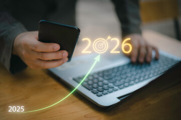 Businessman touching 2026 with arrow target icon, representing new year business goal, strategic planning, vision, annual growth and roadmap for success from 2025 to the future.