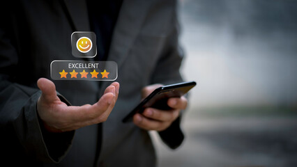 Businessman using smartphone to give five-star positive review with smiley face icon, Customers give 5-star reviews,symbolizing excellent customer feedback, and user satisfaction in digital service.