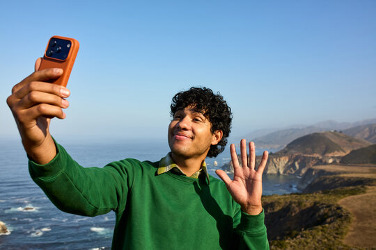 Excited man captures selfies on Pacific coast