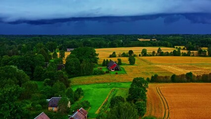 Dramatic storm shelf cloud approaches rural farmland with golden fields and homestead - Powered by Adobe