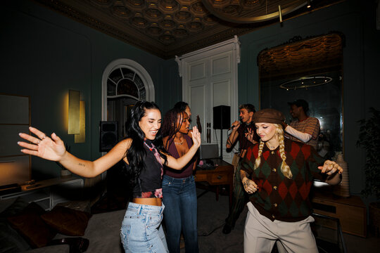 Group of friends celebrating dancing at home