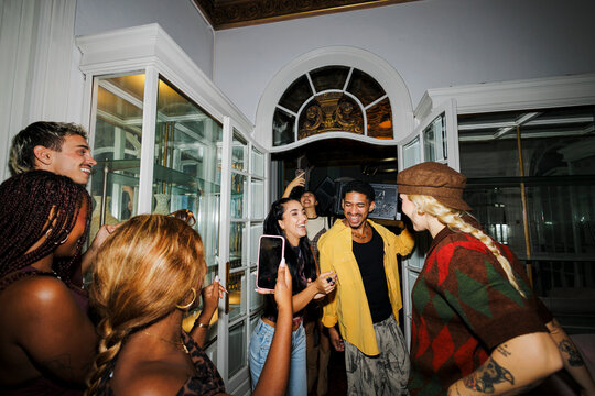 Young friends arriving at home party with music