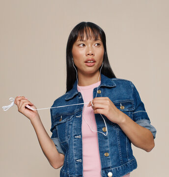 Young Woman in Denim Jacket Listening to Music Indoors