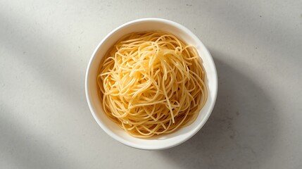 Overhead view of a white oval bowl filled with golden spaghetti pasta